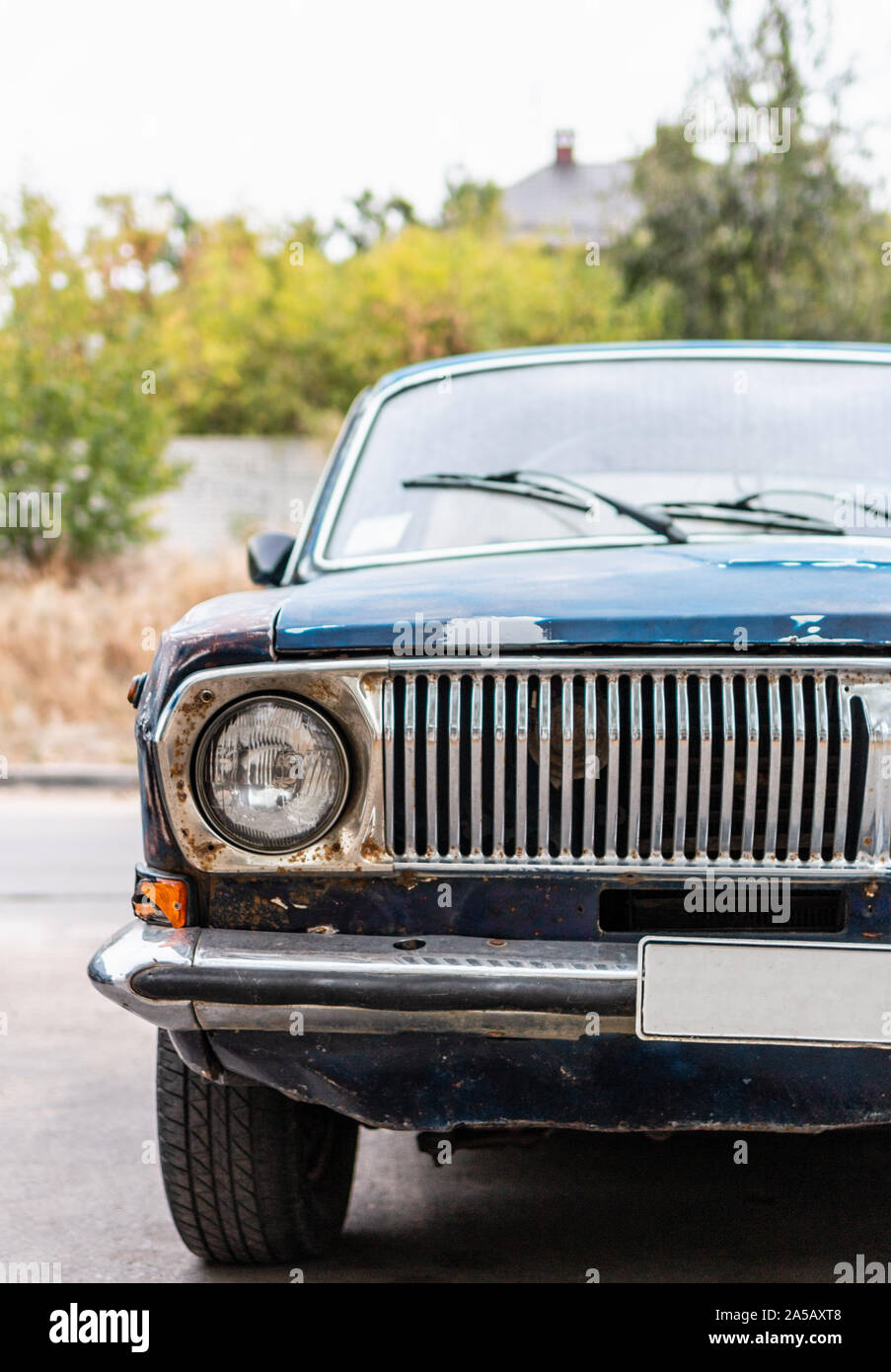 Vertical front view of old dark blue rusty car vehicles with headlight ...