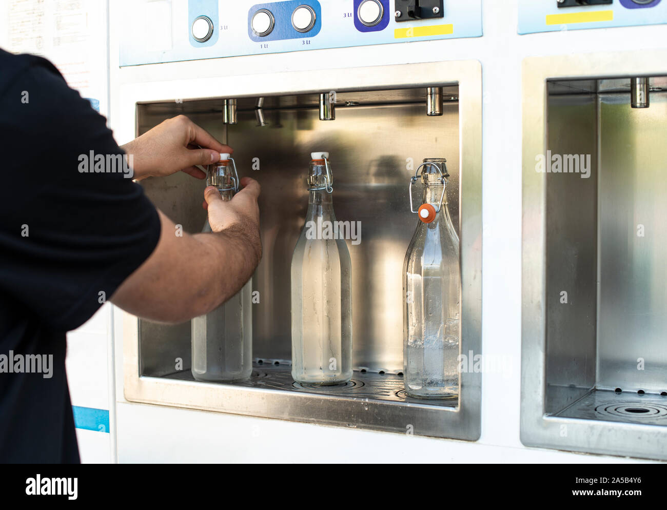 Mineral Water machine on the street. Filling mineral water bottles from a water dispenser. Pay and load drinking water. Stock Photo