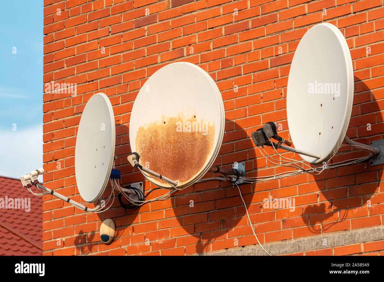 Three Satellite dishes on the brick wall Stock Photo Alamy