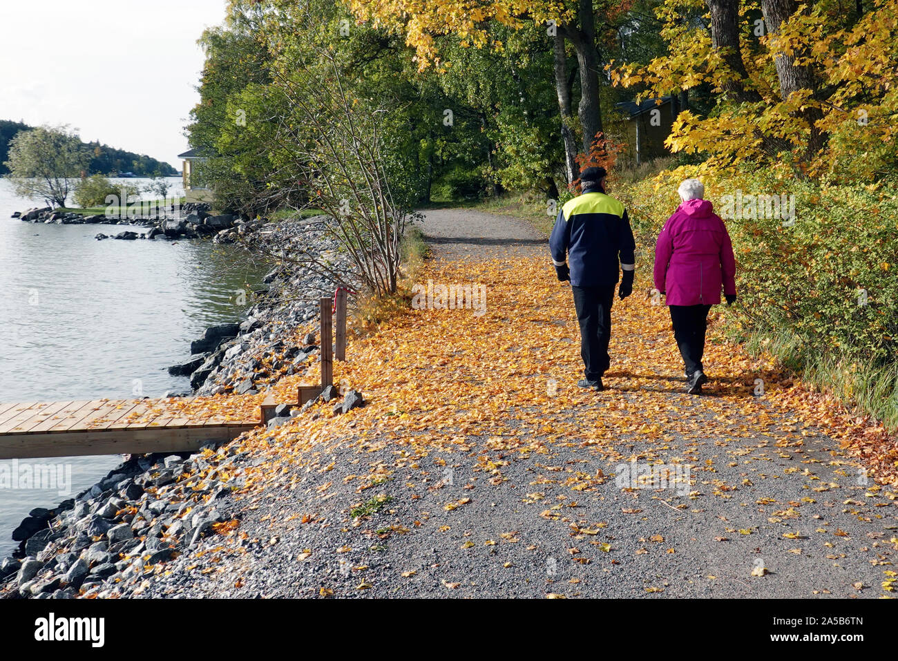Turku, Finland - October 5, 2019: Elderly couple is walking on a footpath next the sea. Location: Ruissalo island Stock Photo