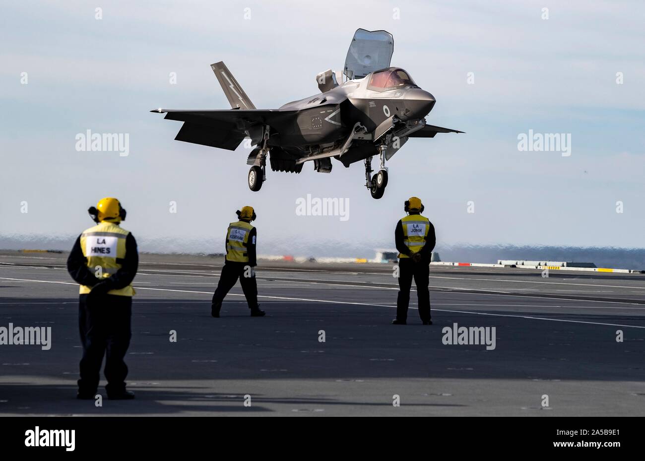 A Royal Navy F-35B Lightning stealth fighter aircraft performs a vertical landing on the flight deck of the HMS Queen Elizabeth during flight operations October 17, 2019 in the Atlantic Ocean. HMS Queen Elizabeth, is the largest warship ever built by the Royal Navy and is currently deployed in support of exercise WESTLANT 19. Stock Photo