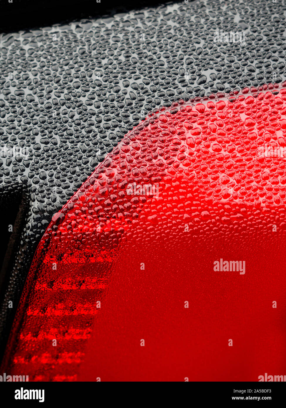 Wet beautiful car Headlamp, black car with water drop. Close up Side view shot from side of vehicle. Detailing concept. Stock Photo