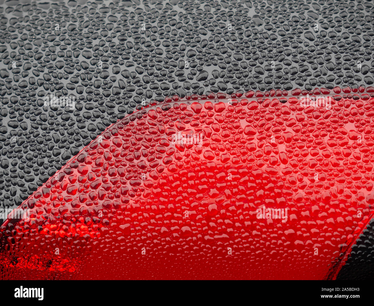 Wet beautiful car Headlamp, black car with water drop. Close up Side view shot from side of vehicle. Detailing concept. Stock Photo