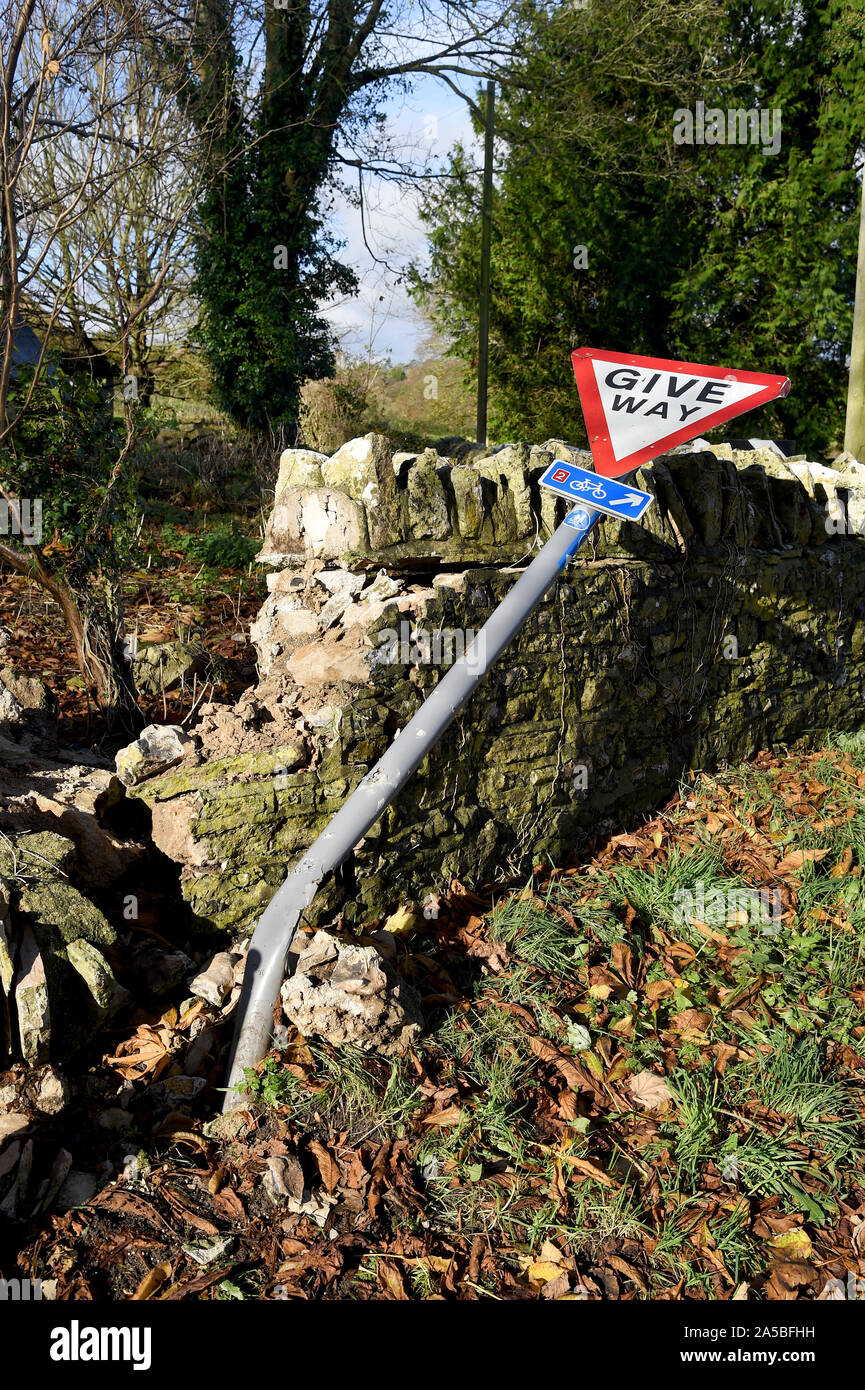 Give Way sign and wall that has been knocked down, England Stock Photo