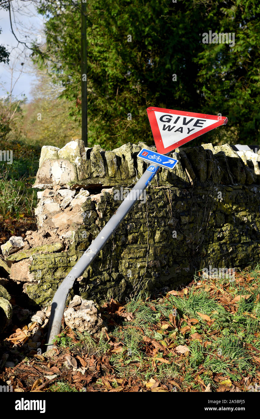 Give Way sign and wall that has been knocked down, England Stock Photo
