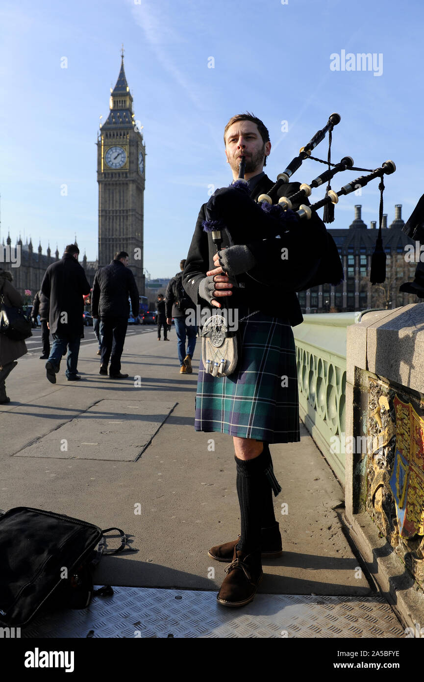Man plays bagpipes by Big Ben, London, UK Stock Photo
