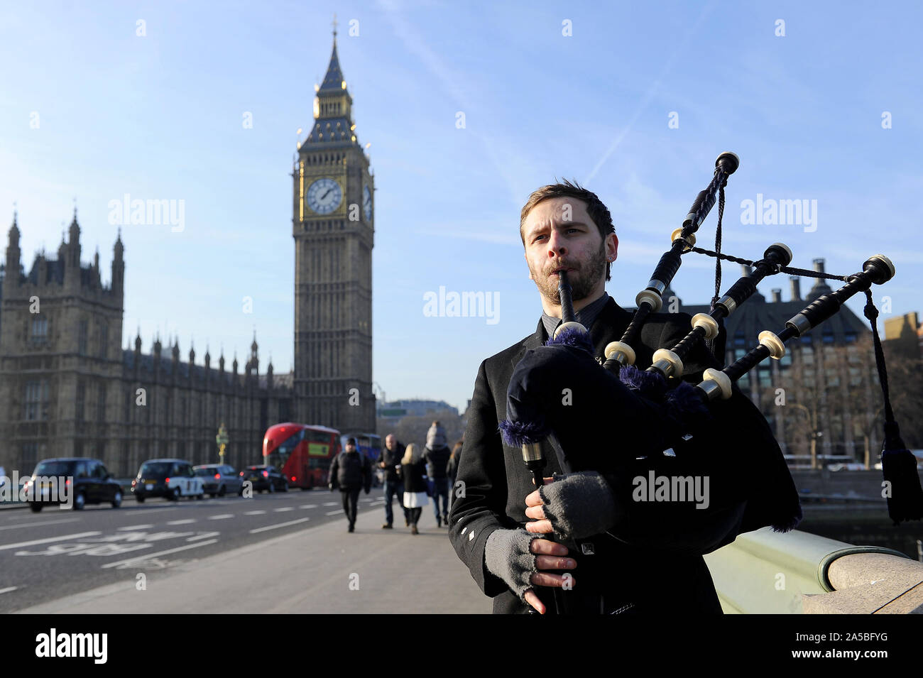 Man plays bagpipes by Big Ben, London, UK Stock Photo