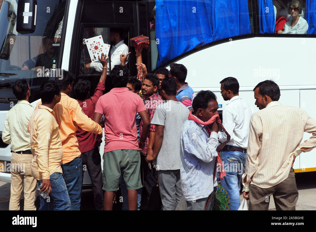 A tourist coach is besieged with souvenir sellers near to the Taj Mahal in Agra, India. Stock Photo