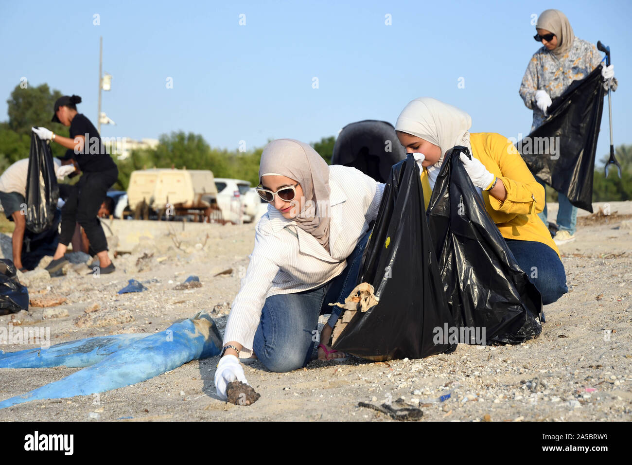 Kuwait City, Kuwait. 19th Oct, 2019. Volunteers collect trash on the sea beach in Kuwait City, Kuwait, on Oct. 19, 2019. A local group named Trashtag Kuwait launched a sea beach cleaning campaign in April this year. Every week the group organized events to clean sea beaches in Kuwait. According to Yousef Al-Shatti, one of the organizers of the event, the group consists of about 100 volunteers in Kuwait and aims to spread environmental awareness among people and reduce pollution. Credit: Ghazy Qaffaf/Xinhua/Alamy Live News Stock Photo