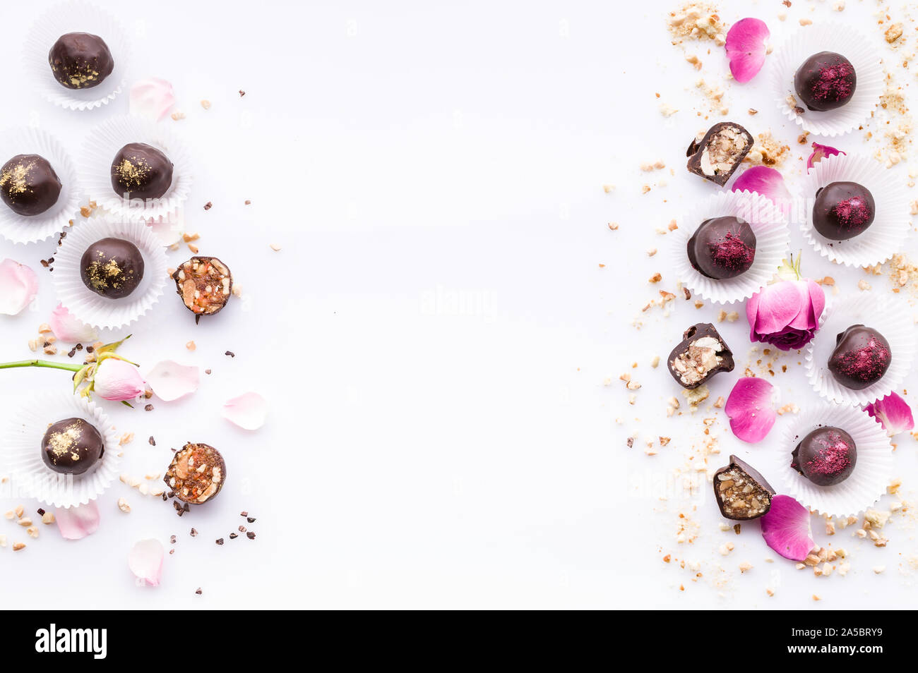 Sweet pattern. Top view handmade chocolate candies with nuts and honey. Gourmet chocolates on a white background. Close-up. Soft focus. Copy space Stock Photo