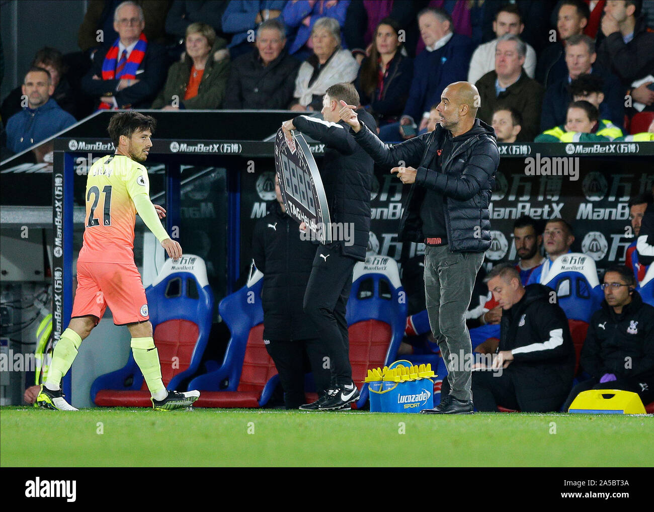 19th October 2019; Selhurst Park, London, England; English Premier League Football, Crystal Palace versus Manchester City; Manchester City manager Pep Guardiola gives instructions from the touchline during the 2nd half with David Silva of Manchester City looking at Manchester City manager Pep Guardiola while being subbed off - Strictly Editorial Use Only. No use with unauthorized audio, video, data, fixture lists, club/league logos or 'live' services. Online in-match use limited to 120 images, no video emulation. No use in betting, games or single club/league/player publications Stock Photo