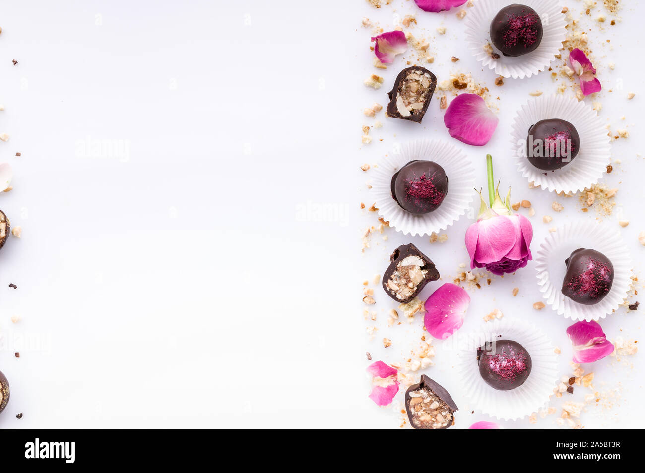 Sweet pattern. Top view handmade chocolate candies with nuts and honey. Gourmet chocolates on a white background. Close-up. Soft focus. Copy space Stock Photo