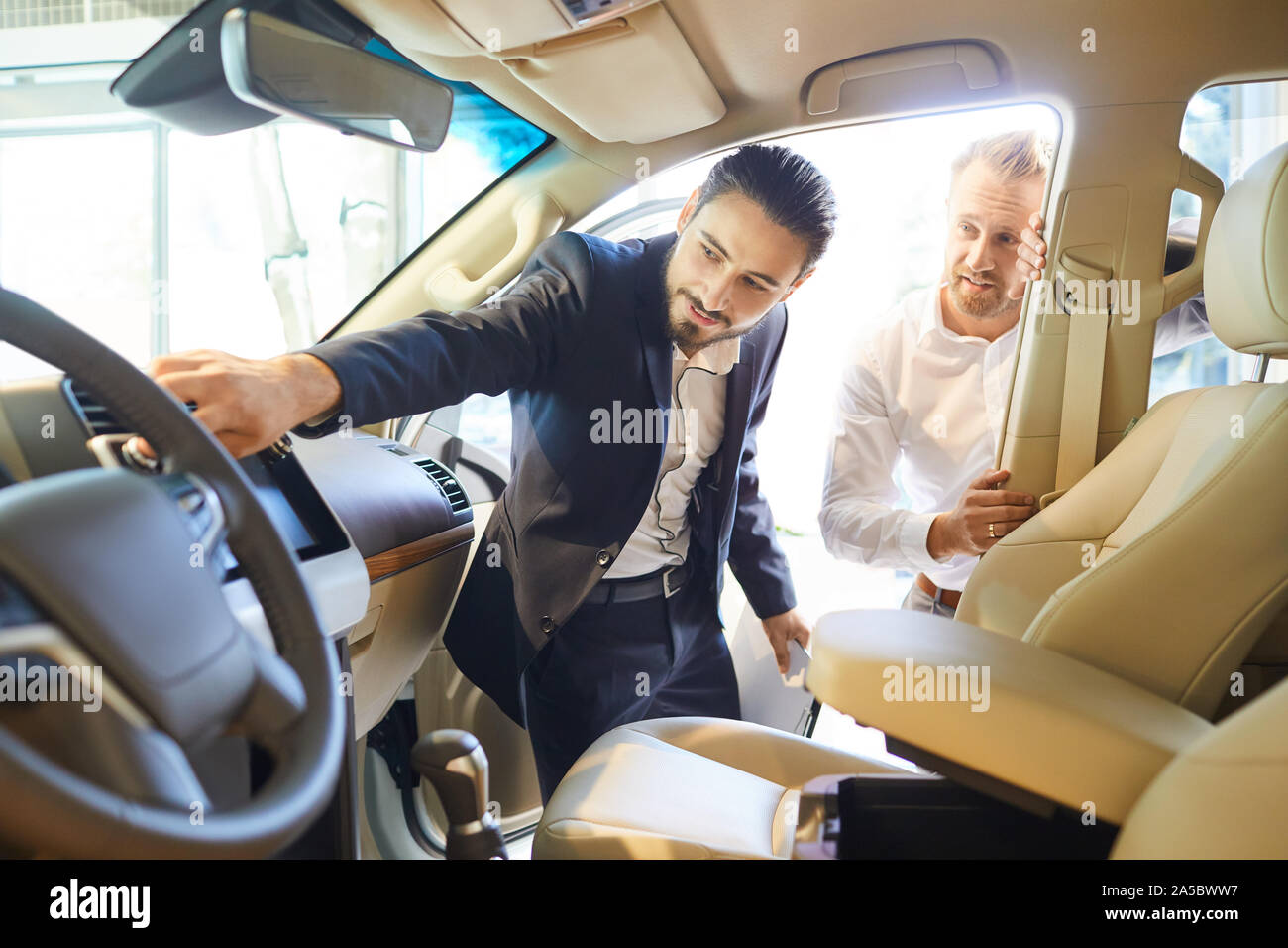 Professional salesmen selling cars at dealership to buyer Stock Photo