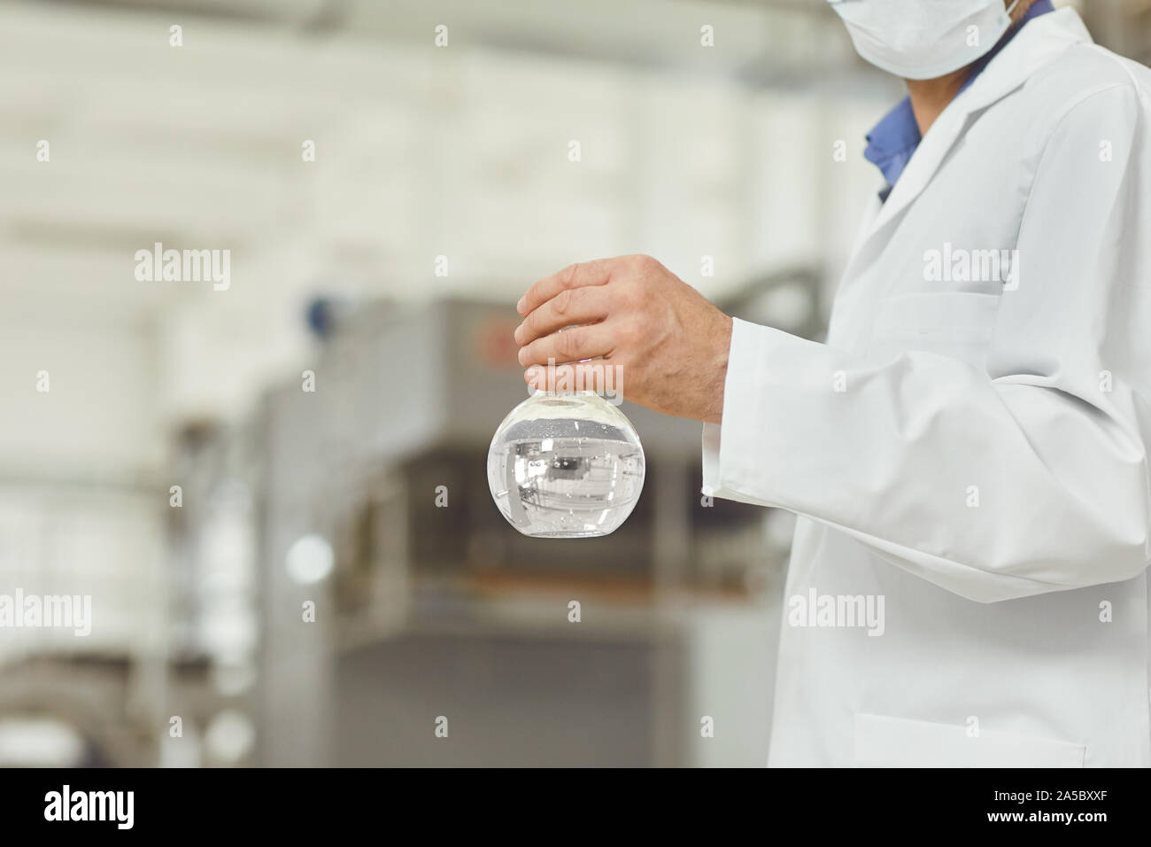 The flask with the water test in the hands of the technologist on the factory. Stock Photo