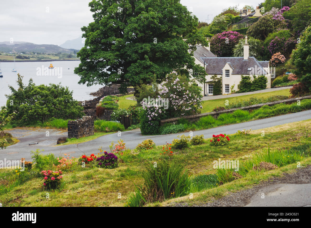 A manicured house and garden overlooking the harbour in Portree, United Kingdom Stock Photo