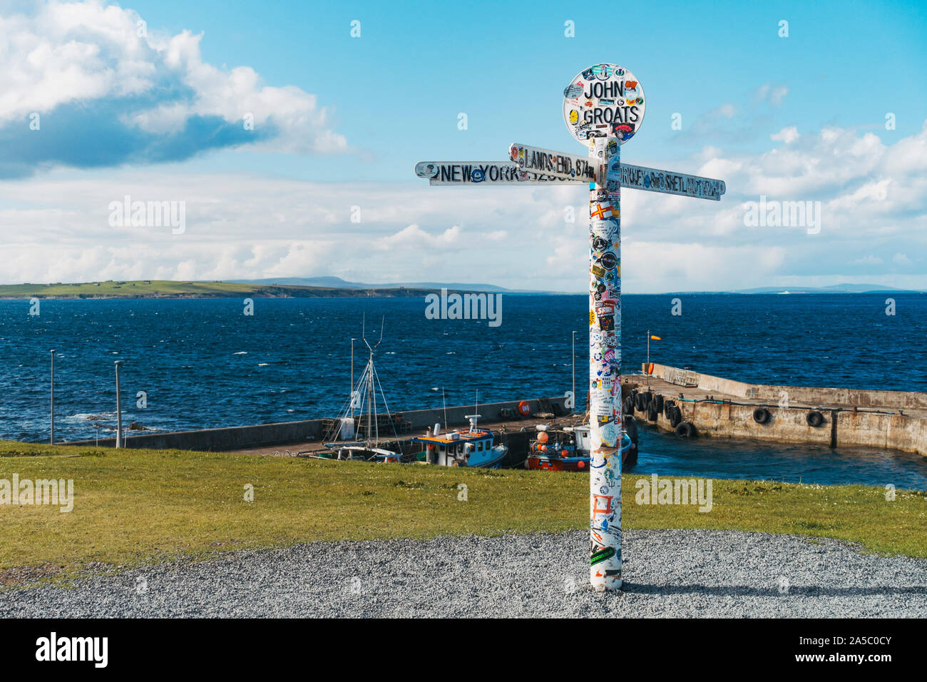 the famous John o'Groats signpost pole, plastered with stickers from tourists, at the far north eastern point of the UK Stock Photo