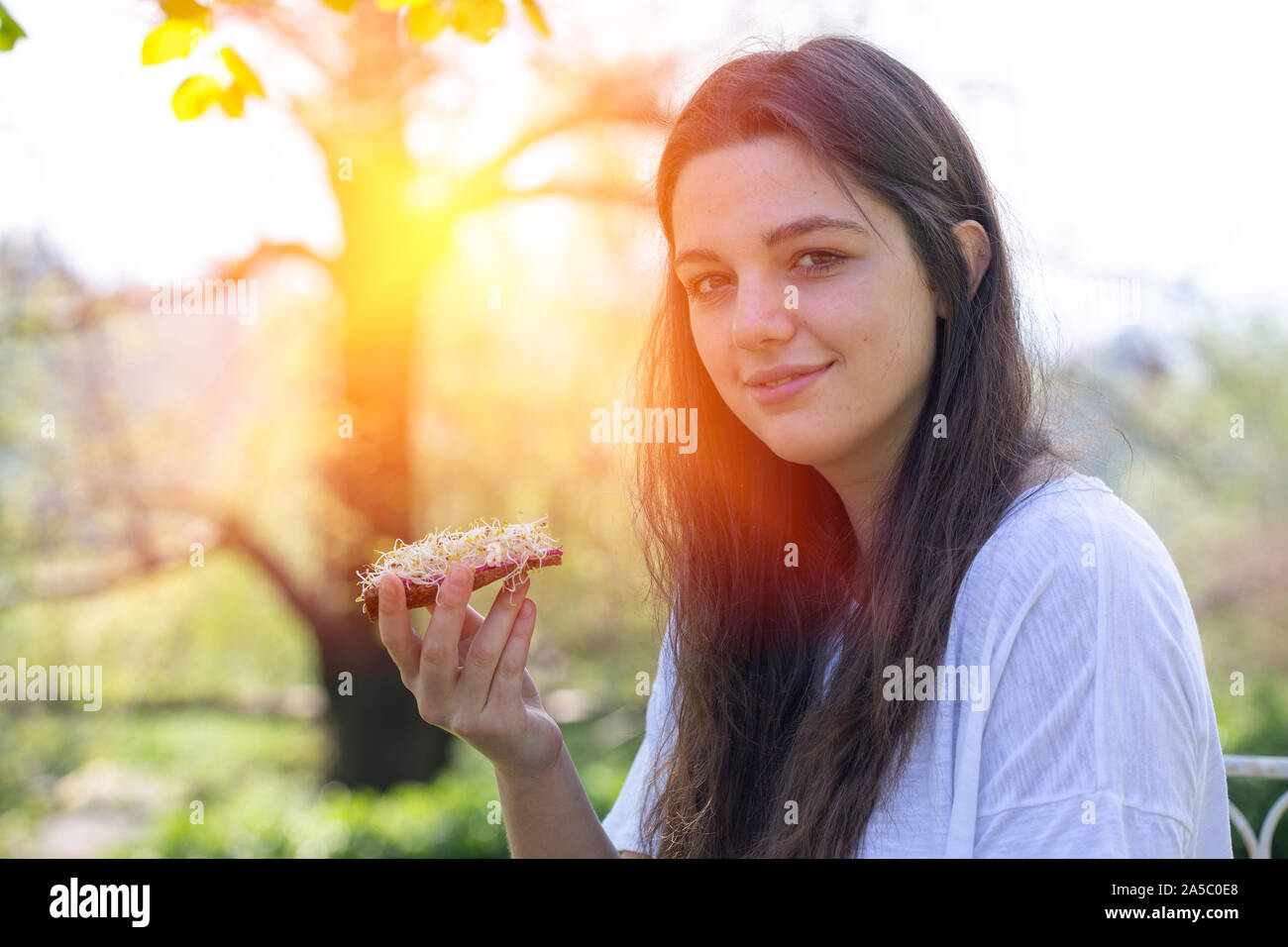 Portrait of young woman eating healthy food in the park Stock Photo