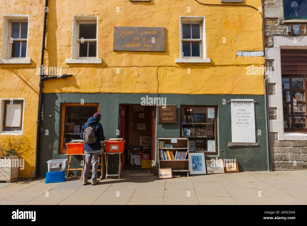 A man browses vinyl records out the front of a second hand book and record shop in Thurso, Scotland - the northernmost town on British mainland. Stock Photo
