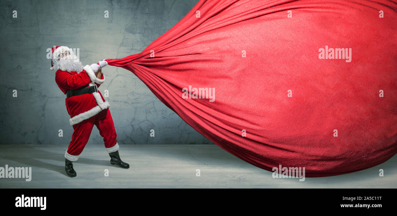 Santa Claus with big bag on blank advertisement banner with copy space. Christmas theme, sales - Image Stock Photo