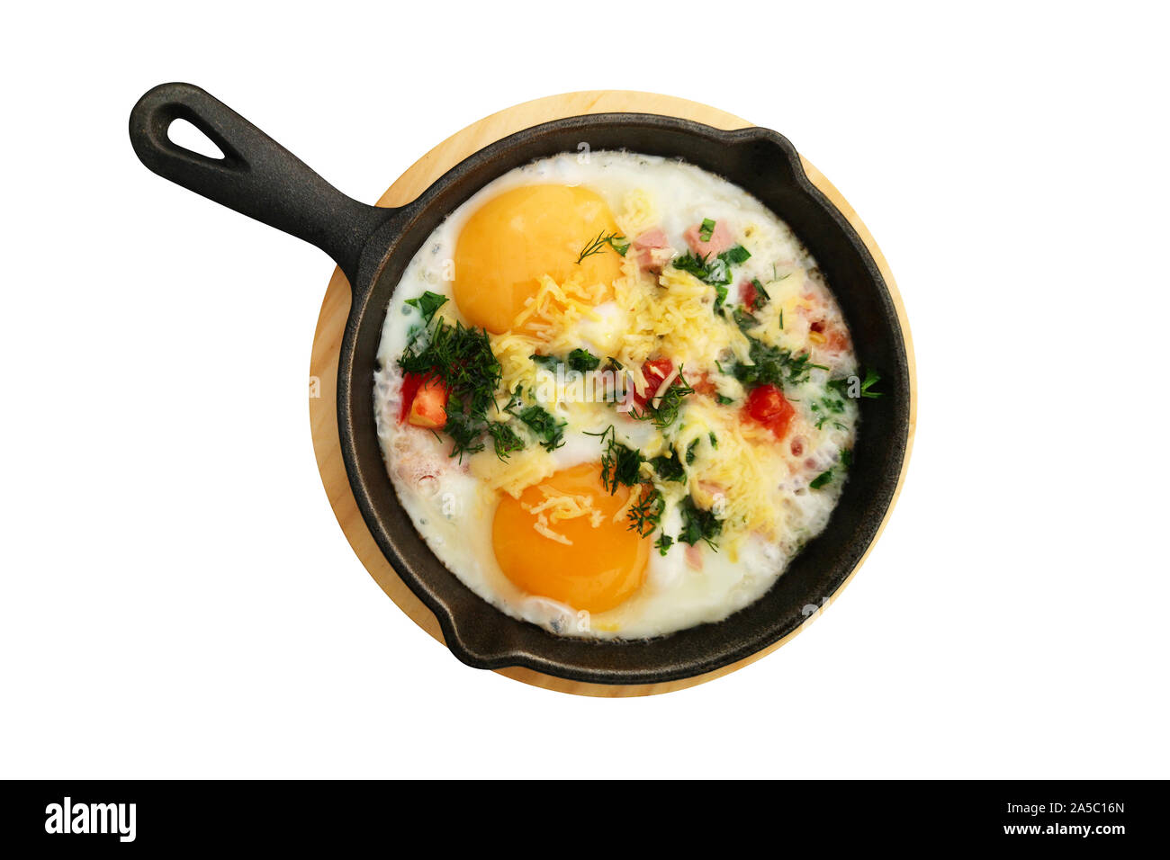 Fried eggs with vegetables in frying pan isolated on white background. Top view. Stock Photo