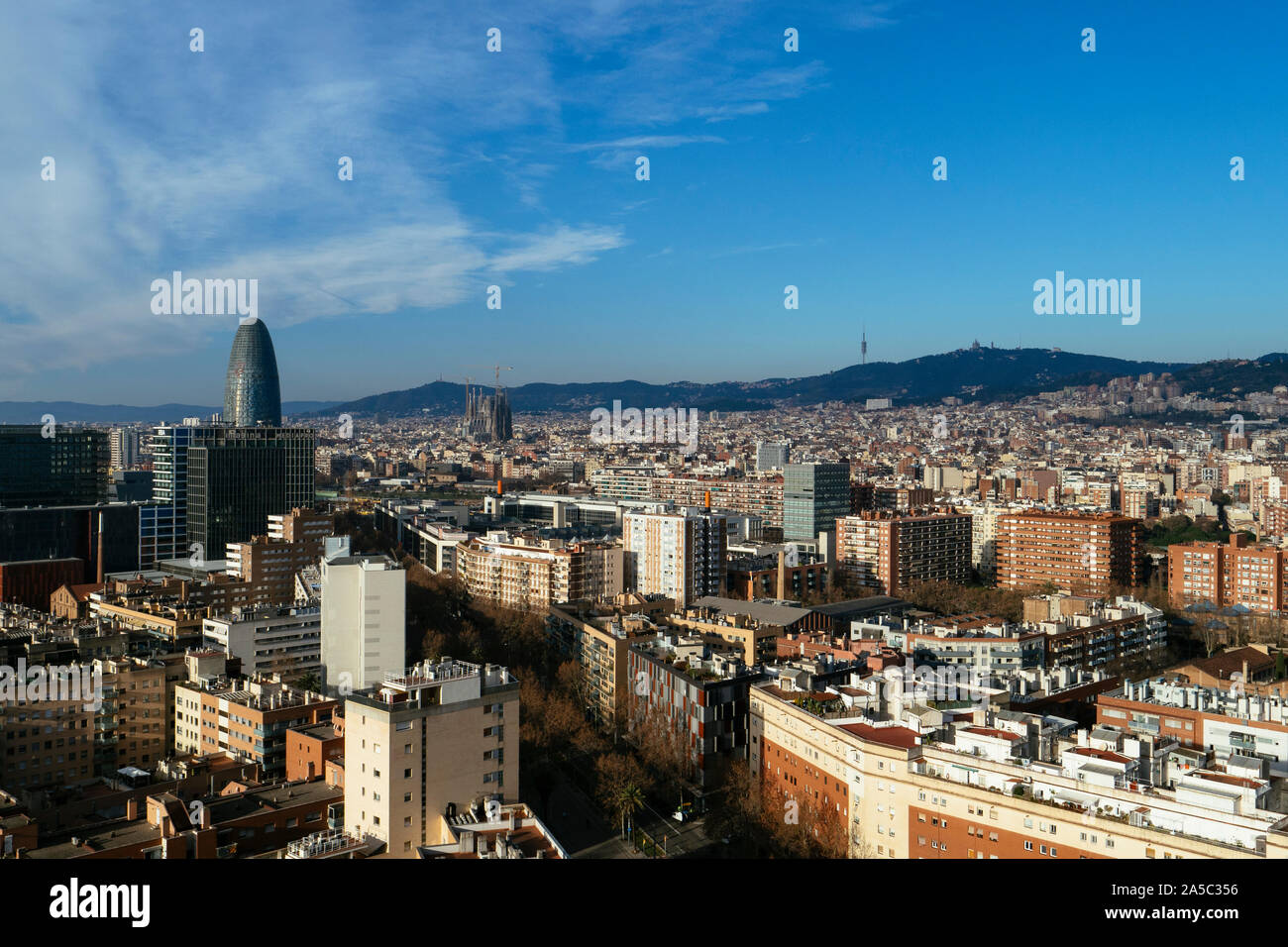 Barcelona city skyline featuring famous landmarks Torre Glories, La Sagrada Familia and the hillside of Tibidabo in the distance - Barcelona, Cataloni Stock Photo