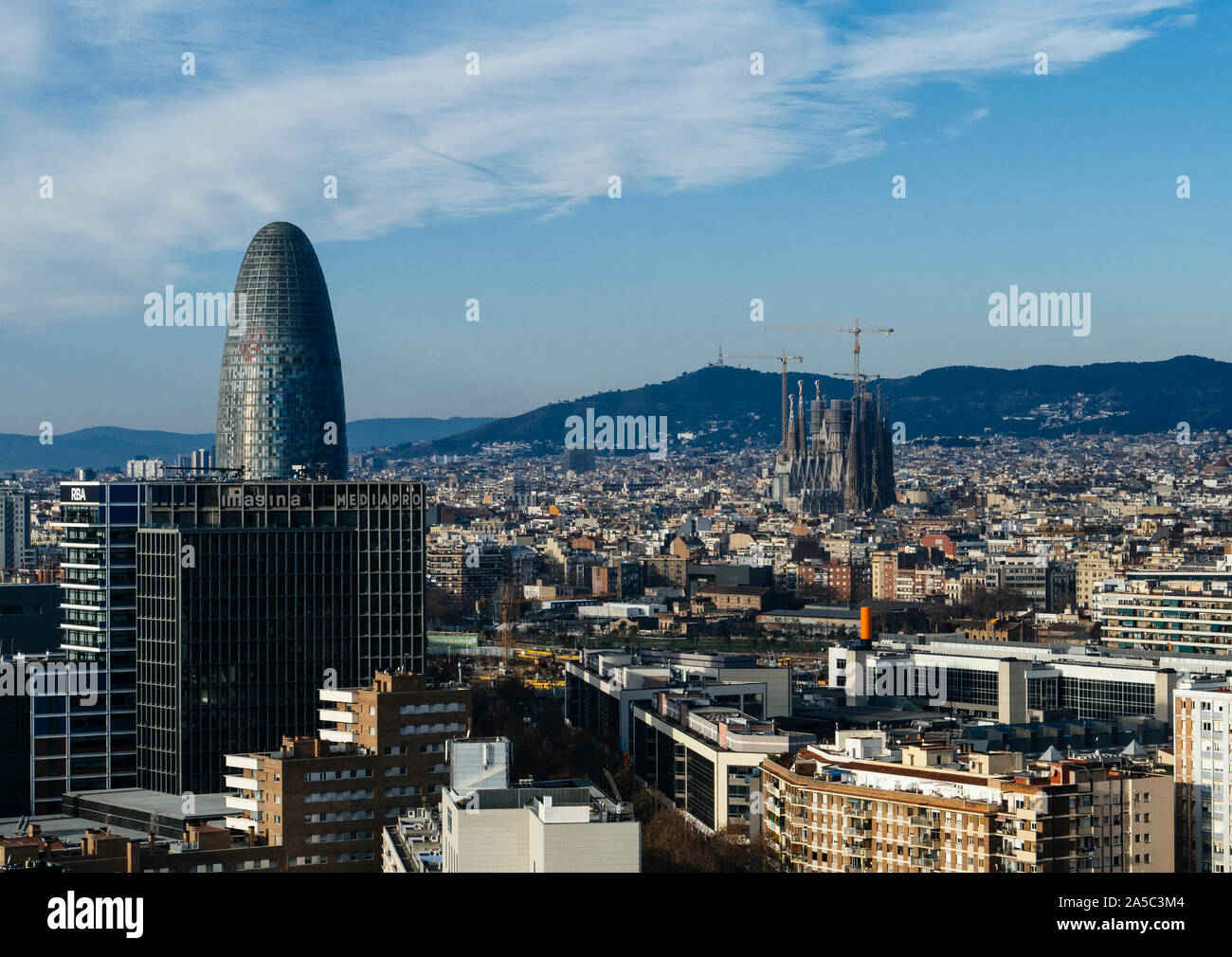 Cityscape with famous landmarks Torre Glories and La Sagrada Familia  towering above the city of Barcelona, Catalonia, Spain Stock Photo