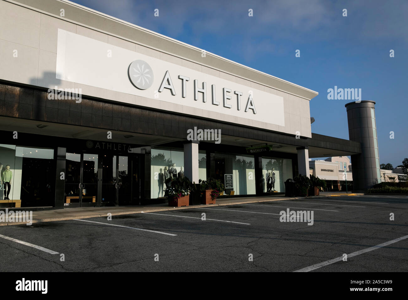 A logo sign outside of a Athleta retail store location in Greensboro, North Carolina on