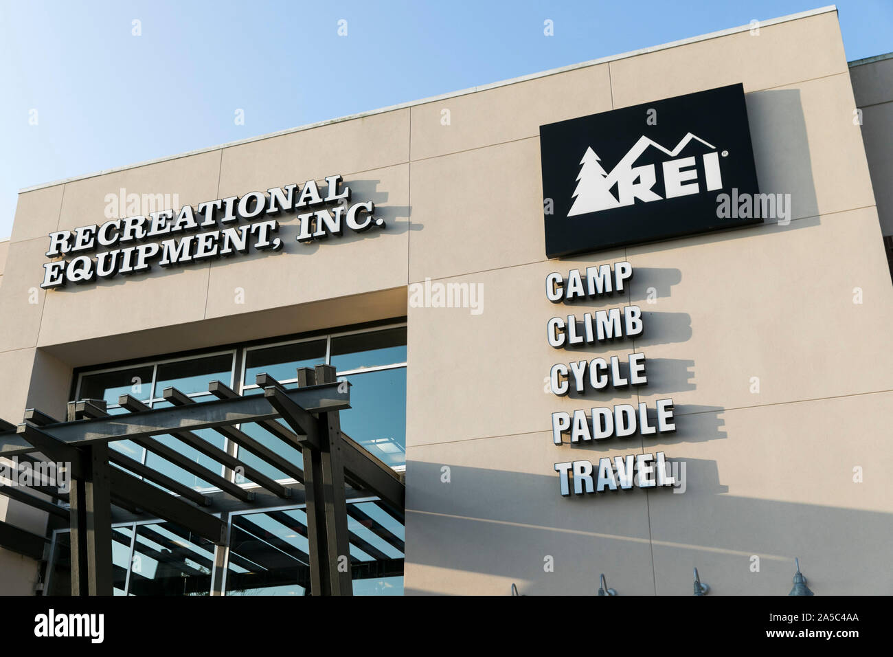 A logo sign outside of a Recreational Equipment, Inc. (REI) retail