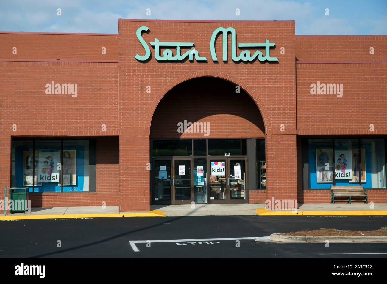 A logo sign outside of a Stein Mart retail store location in Greensboro