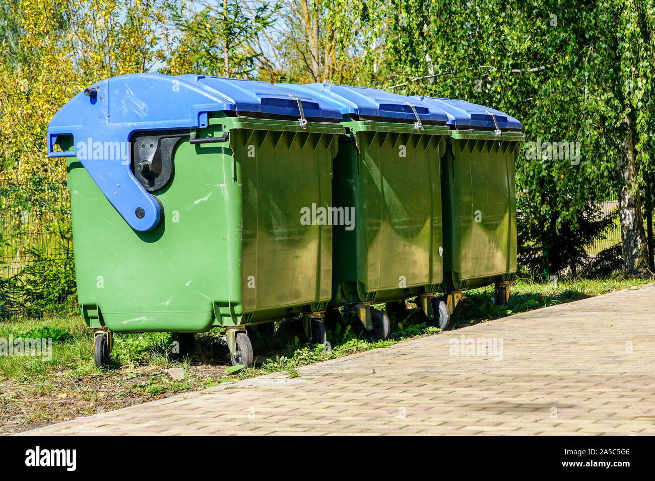 three large green plastic waste bins on wheels Stock Photo Alamy