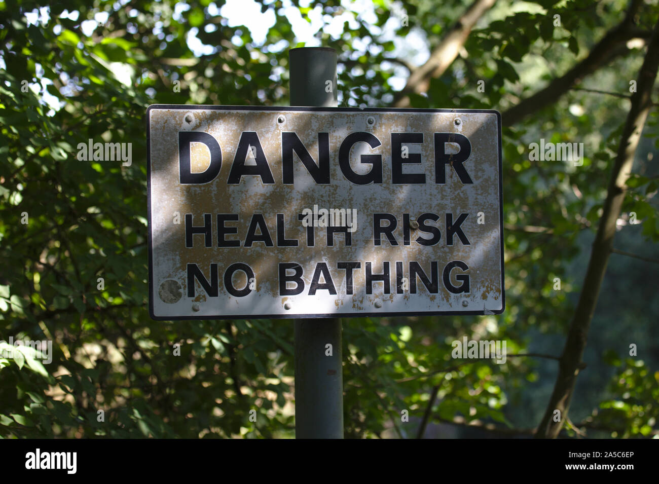 Danger health risk no bathing sign by side of lake in Country Park. UK Stock Photo