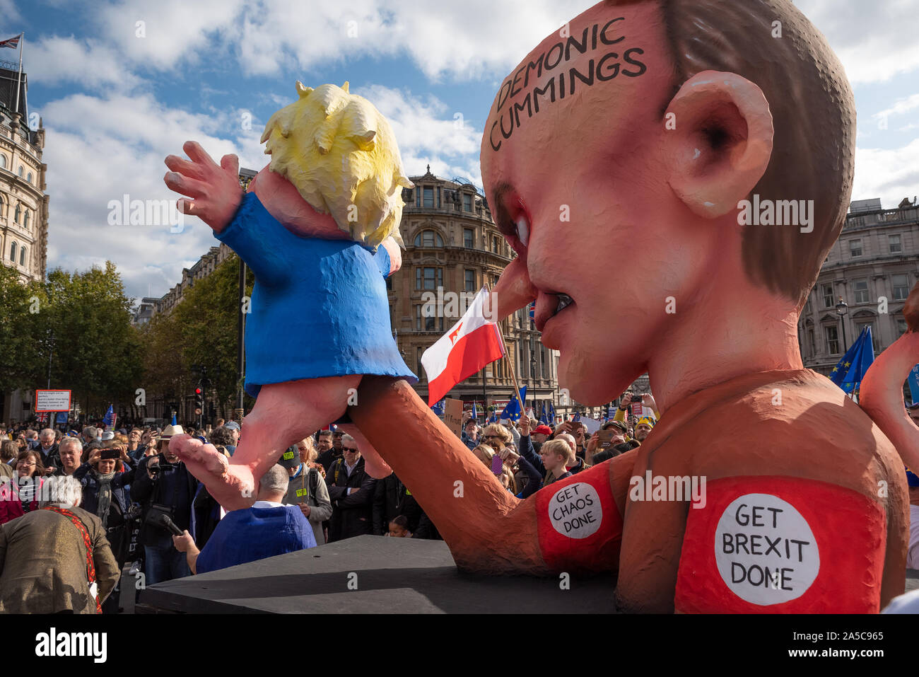 London, UK, 19 Oct 2019. Peoples Vote March. While Parliament debated the deal negotiated by PM Boris Johnson with the EU hundreds of thousands of anti Brexit protestors marched from Park Lane to Parliament Square. Pictured, Boris Johnson and Dominic Cummings effigies on small float parked in Trafalgar Square. Boris Johnson depicted as Dominic Cummings puppet. The Dominic Cummings effigie has Demonic Cummings written on its head, horns and a tail. Credit: Stephen Bell/Alamy Stock Photo