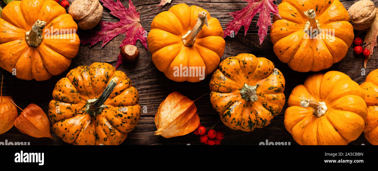 Autumn decorative pumpkins with fall leaves on wooden background ...