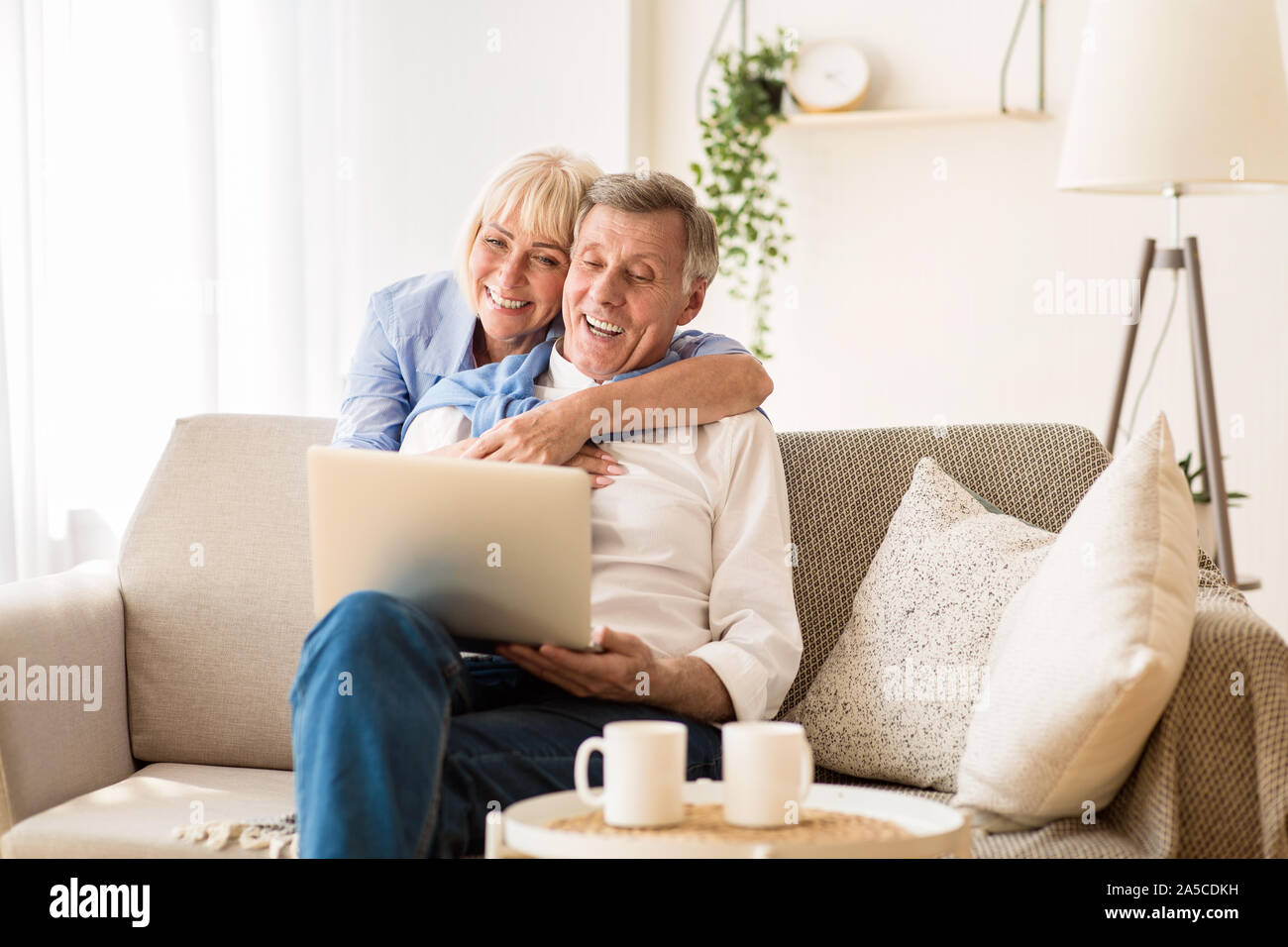 Happy senior couple having video call on laptop Stock Photo