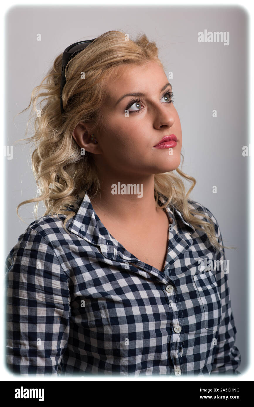 Beautiful young blond woman models various fashions in studio. Stock Photo