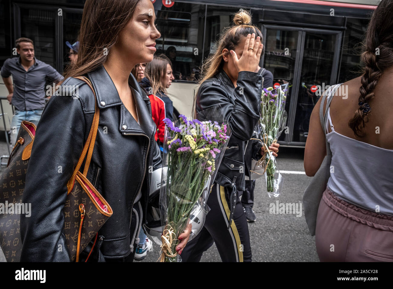 Barcelona, Spain. 19th Oct, 2019. Two young women carry bouquets to pay tribute to the national police.Morning of a press conferences of political parties representing the Spanish unionism in Catalonia and spontaneous tributes to support yesterday's police actions in front of the central police station of Vía Laietana. Credit: SOPA Images Limited/Alamy Live News Stock Photo