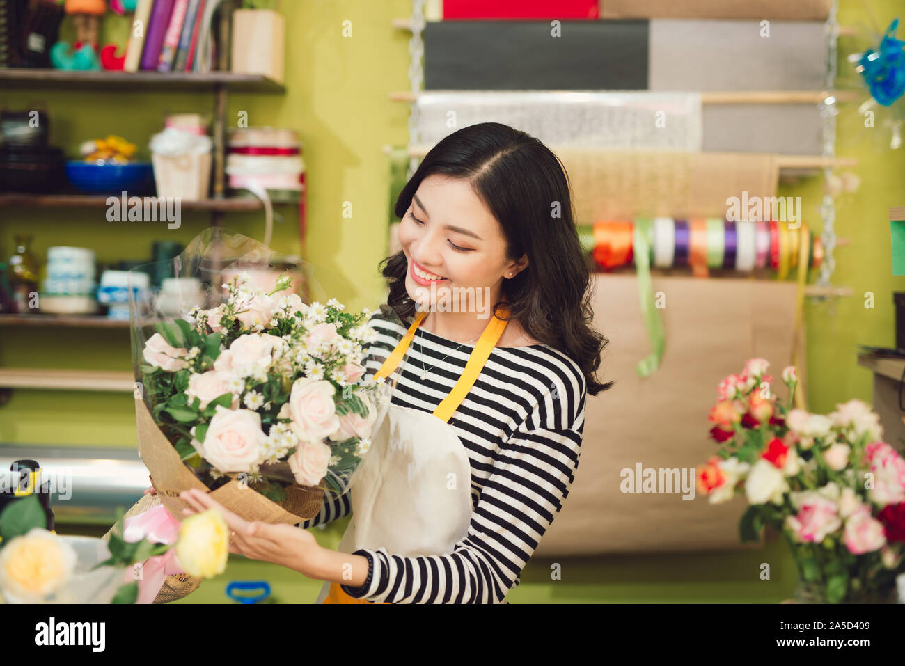 Beautiful asian female florist holding bouquet of flowers Stock Photo ...