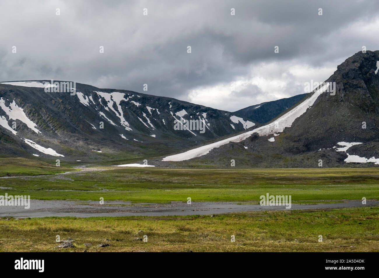 Snow partially covers the hills on the tundra in Siberia, Russia Stock Photo