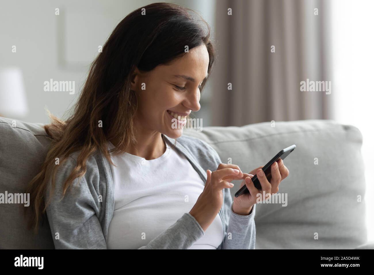 Happy mixed race millennial girl using mobile phone applications Stock