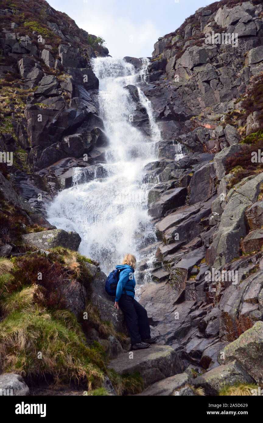 Woman at the Falls of the Glasallt Waterfall after Climbing the Scottish Mountain Munro Lochnagar, Glen Muick, Cairngorms National Park, Scotland. Stock Photo