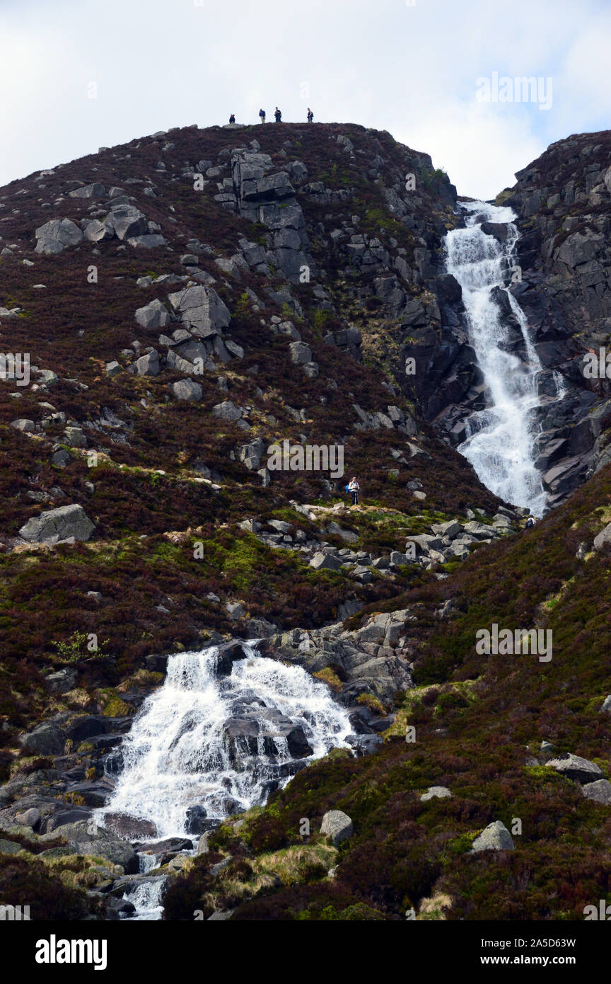 Four Hikers at the Falls of the Glasallt Waterfall after Climbing the Mountain Munro Lochnagar, Glen Muick, Cairngorms National Park, Scotland. UK. Stock Photo