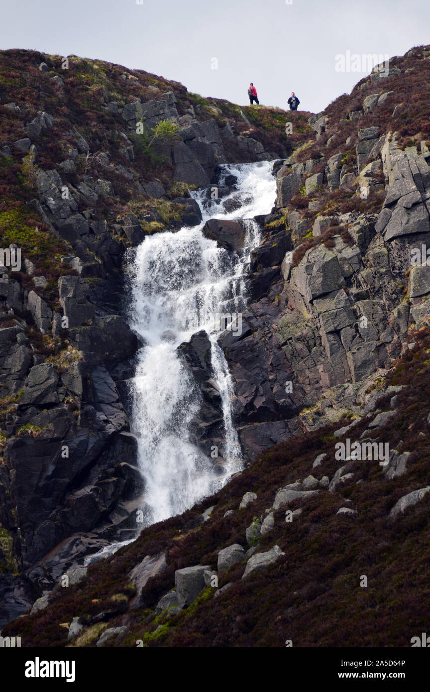 Two Hikers at the Falls of the Glasallt Waterfall after Climbing the Mountain Munro Lochnagar, Glen Muick, Cairngorms National Park, Scotland. UK. Stock Photo