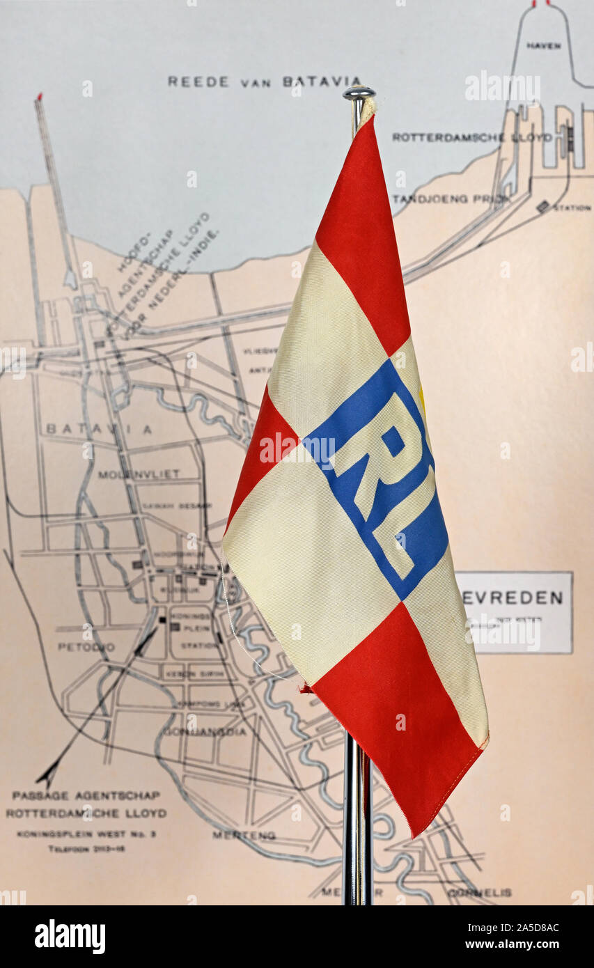 papenburg, germany - 2019.10.19: antique rotterdamsche lloyd table flag in front of batavia map from rl passenger route atlas of 1931 Stock Photo