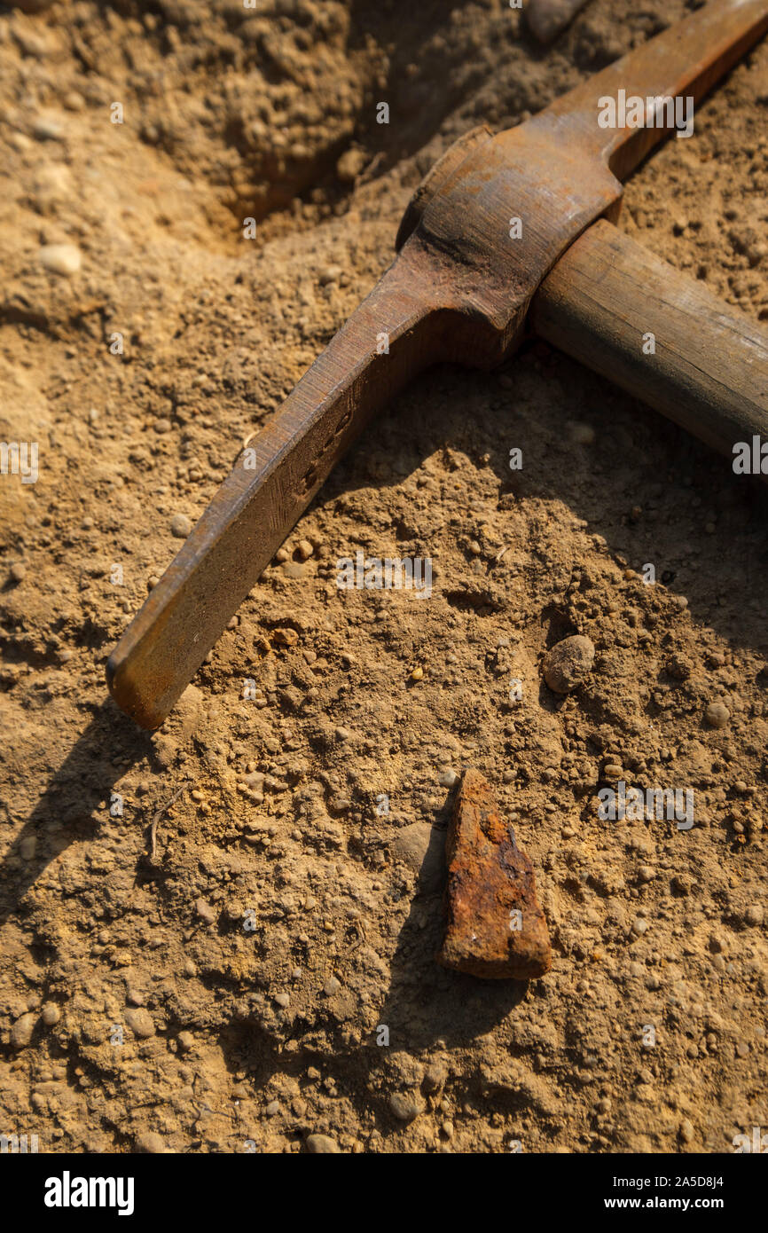 Close up of a pickaxe and a medieval arrow head found on a archaeological dig site Stock Photo