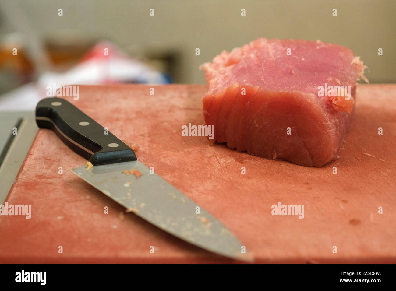 Chef's knife next to a fresh raw tuna fish steak Stock Photo Alamy