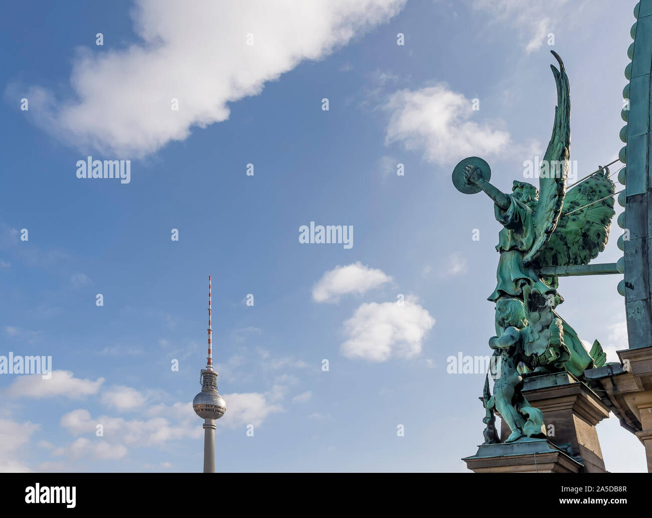 The angel of the dome of the Cathedral of Berlin, Germany and the Television Tower against a beautiful blue sky with some clouds Stock Photo