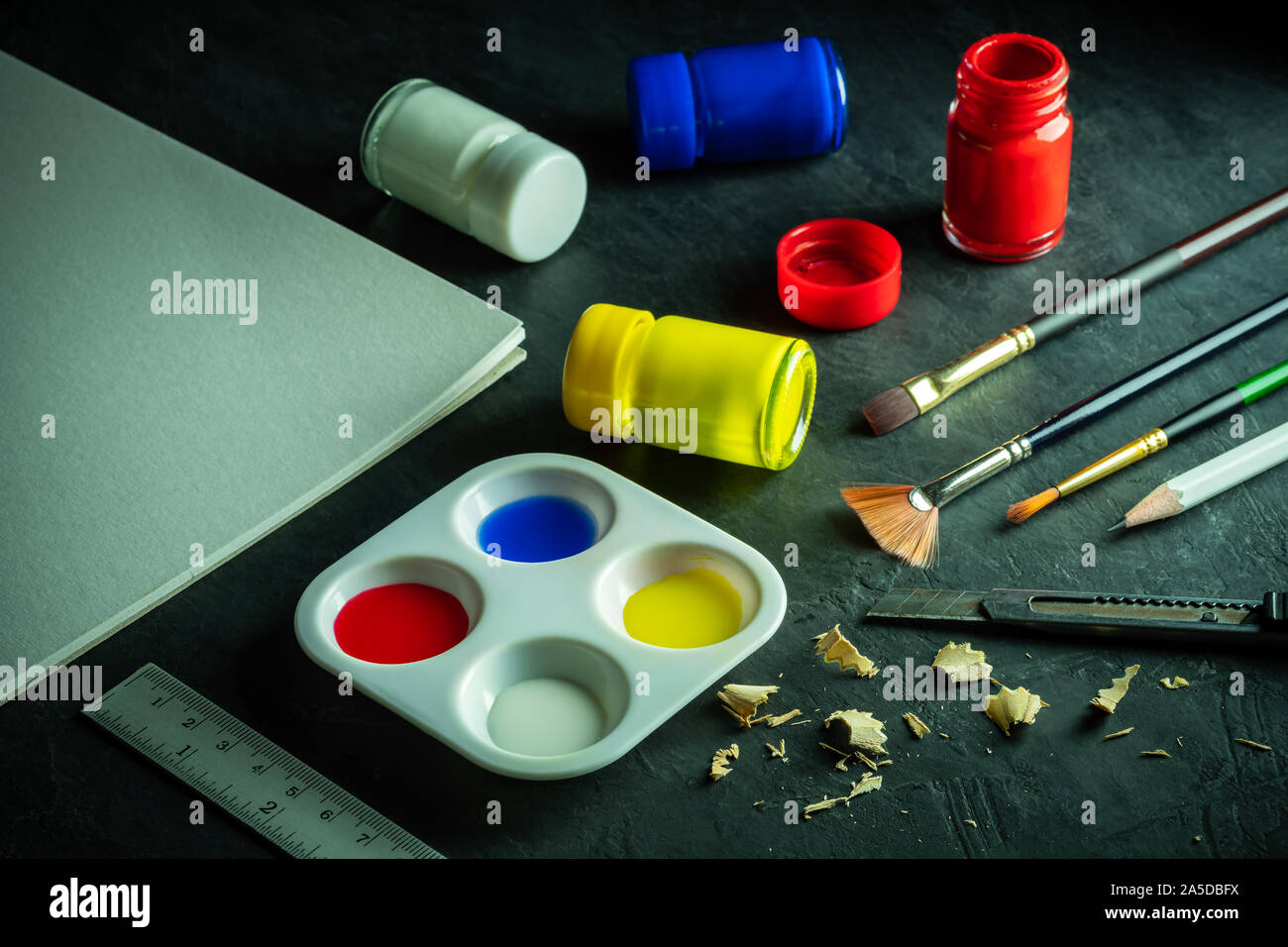 Art materials and poster color bottle on black cement floor. Concept of art education. Stock Photo