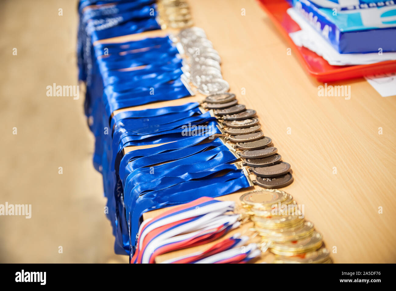 Gold champion winner awards trophies and medals lined up in rows. Selective focus Stock Photo