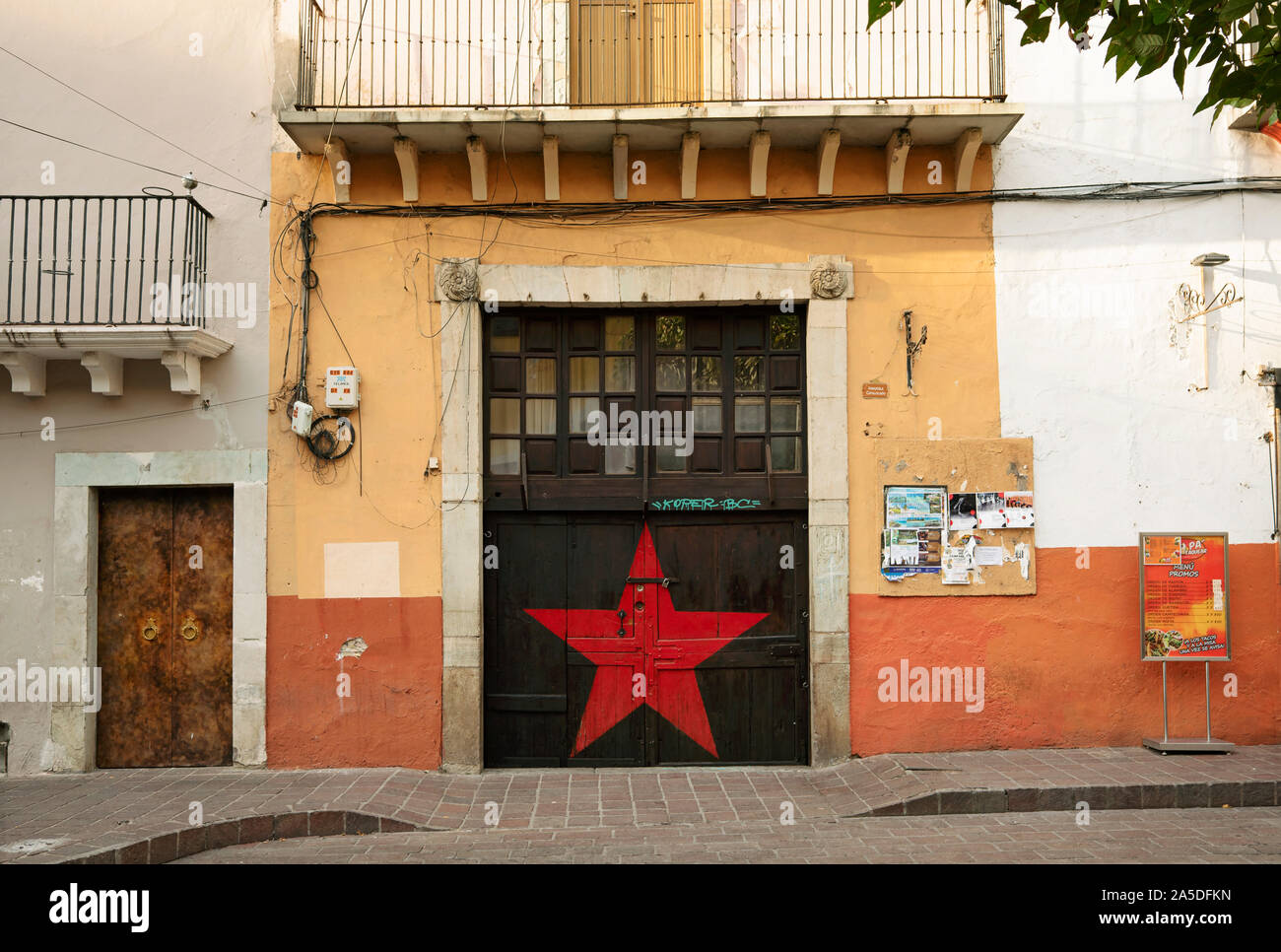 Painted facade of building with Red star painted on door. Manuel Doblado street, Guanajuato, Mexico. Jun 2019 Stock Photo