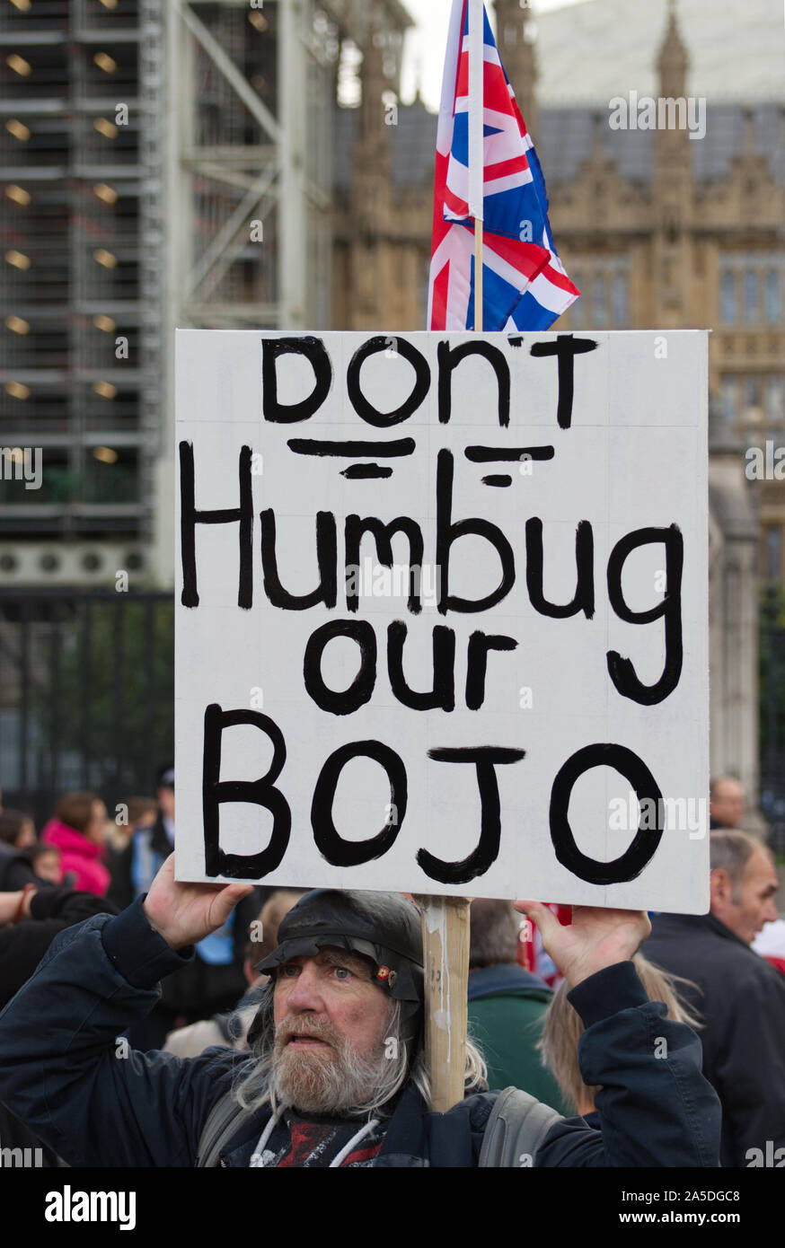 A pro Brexit Boris Johnson fan / supporter in London demonstrating outside the houses of parliament with a sign that reads: Don't humbug our BoJo Stock Photo